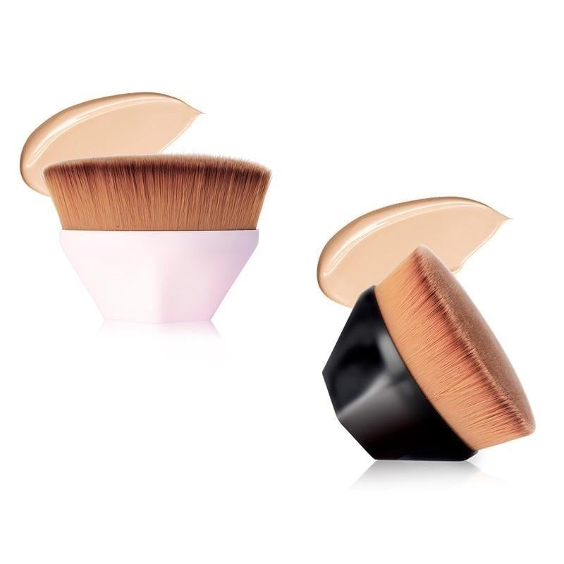 Two high density foundation brushes with dense tapered bristles and sleek matte white and glossy black handles with foundation swatches