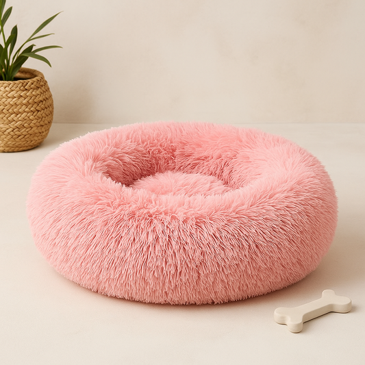 A plush circular pink calming donut bed for dogs and cats with a soft fluffy texture for comfort and relaxation