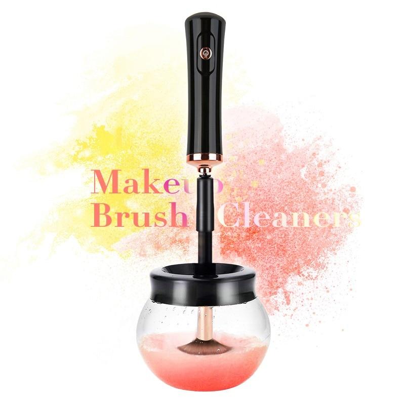 Black and rose gold electric makeup brush cleaner with clear glass base filled with pink liquid for brush drying