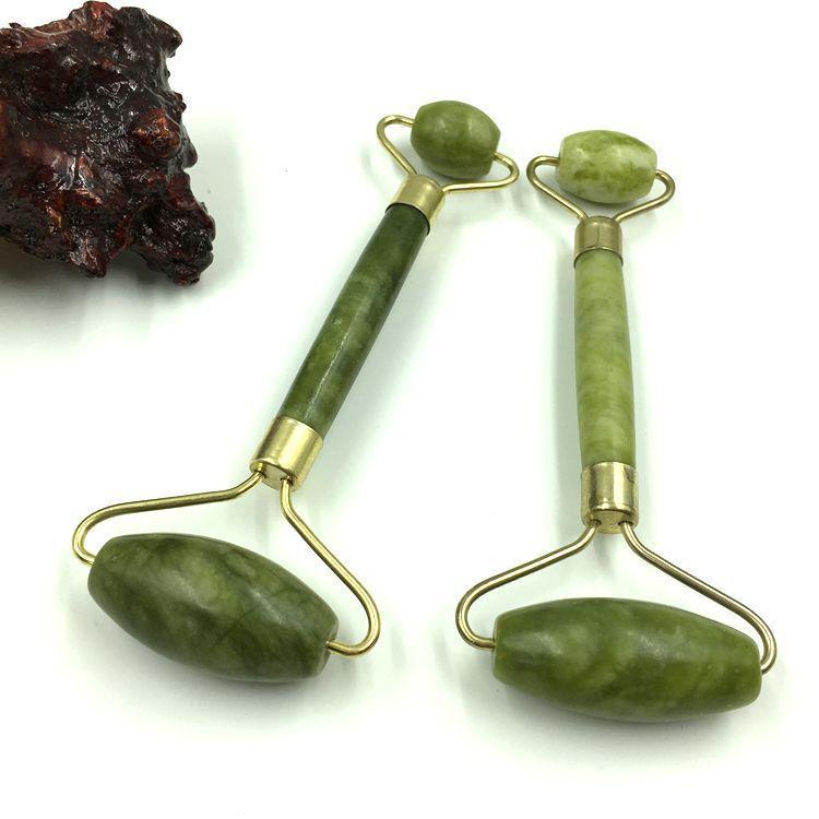 Two jade facial rollers with polished green stone handles and golden metal frames for skincare massage