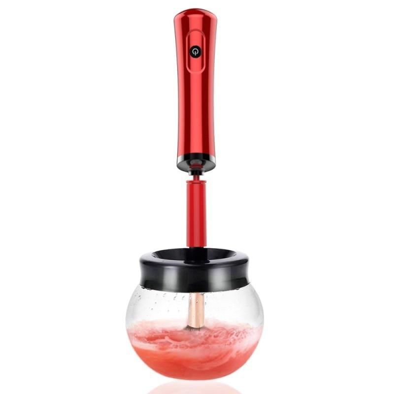 Red electric makeup brush cleaner and dryer with a sleek metallic handle and black accents in a glass jar for easy cleaning