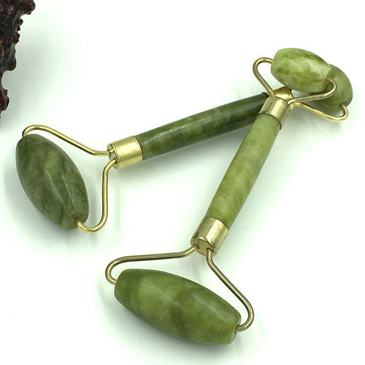 Two jade green double head roller face massagers with gold toned metal handles for facial massage and skincare