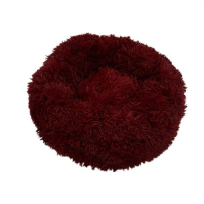 A plush deep red circular calming donut bed with soft shaggy texture for dogs and cats