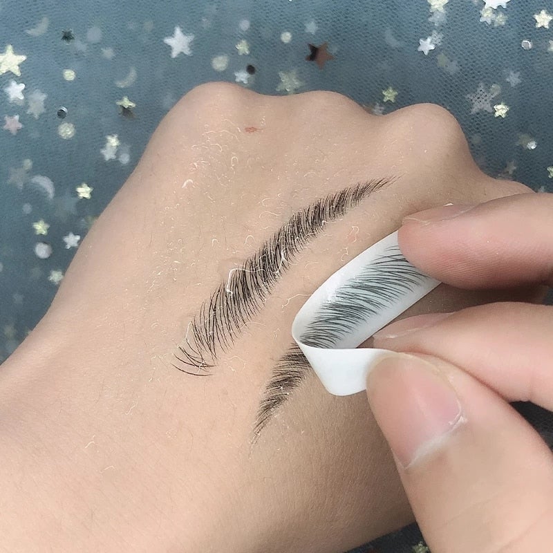 Black faux-mink false eyelash strip on white adhesive backing applied to eyebrow stencil for 4d waterproof eyebrow tattoo stickers