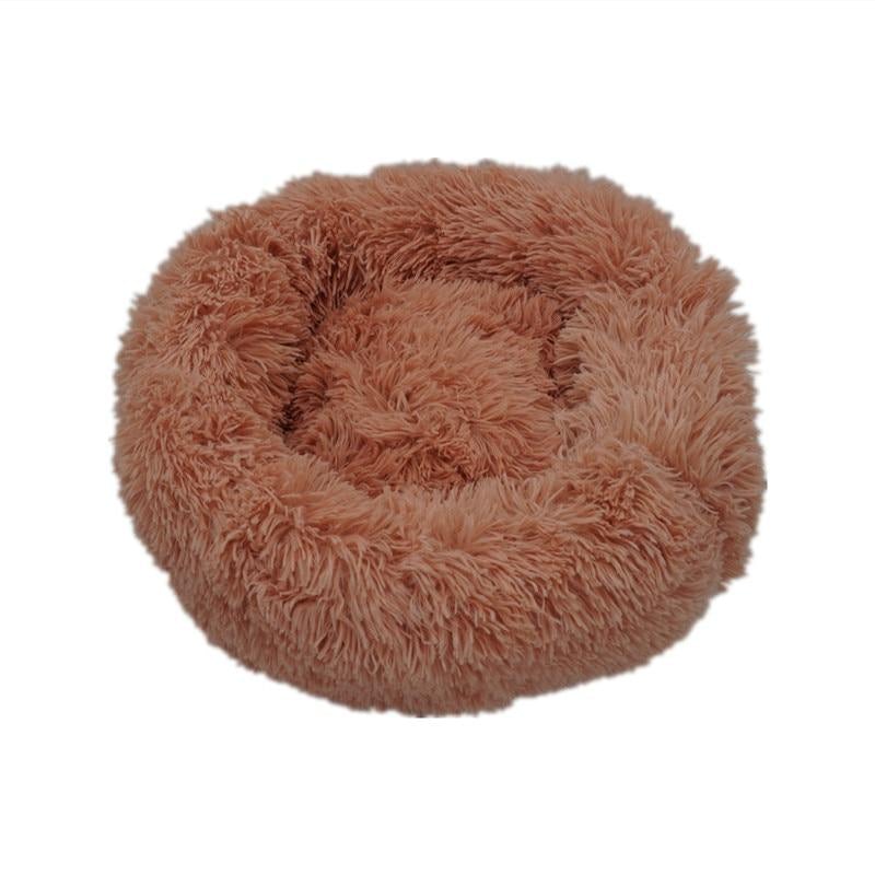 A cozy tan calming donut bed for dogs and cats with plush soft fluffy texture and circular design
