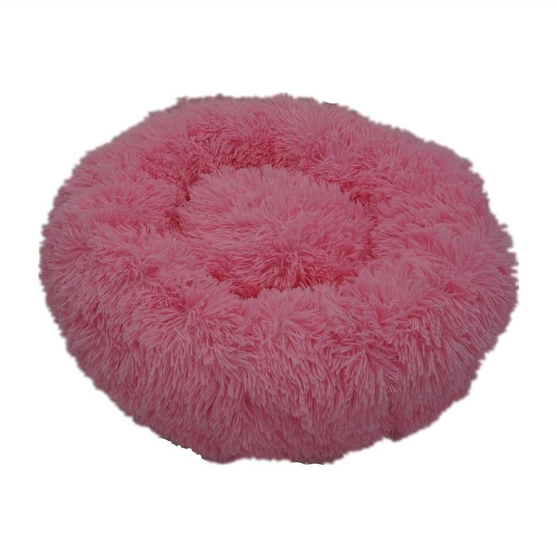 Pink fluffy calming donut bed for dogs and cats with soft plush texture and circular design for comfort and relaxation