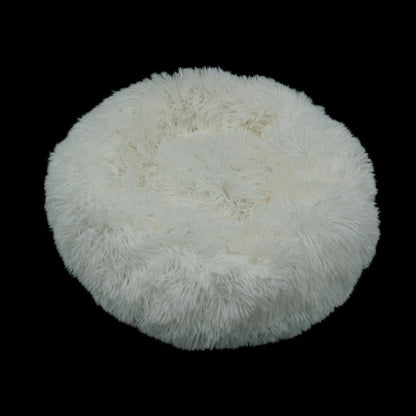 White fluffy faux fur calming donut bed for dogs and cats with round plush design for comfort and relaxation